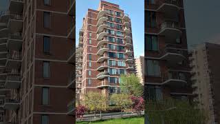 View of trees bushes green grass people and blocks of flats with balconies [upl. by Elumas902]