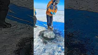 Breaking ice on the lake to prepare for fishing [upl. by Aikemaj250]