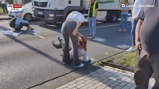 Woman drags climate activist by the hair to stop her from blocking traffic [upl. by Ahsitauq]