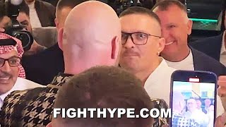 USYK STEPS TO TYSON FURY amp BEAR HUGS HIM OFF THE GROUND DURING FACE TO FACE CONFRONTATION [upl. by Nanette133]