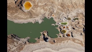 Gekleurde zinkgaten aan de oevers van de Dode Zee in Israël  door dalende waterspiegel [upl. by Jordans570]