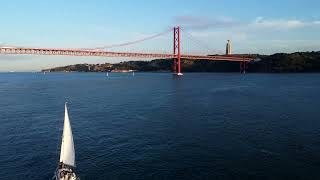 Sailboat under 25 april bridge in Lisbon  Drone 4K aerial view [upl. by Etteneg]