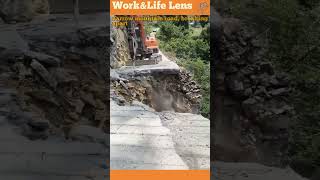 An excavator equipped with a jackhammer is working on a narrow mountain road [upl. by Affrica681]