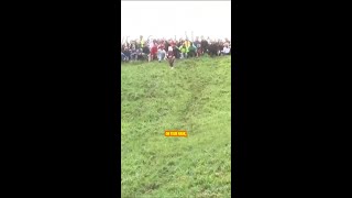 🧀 People tumble down hill chasing wheel of cheese in annual cheeserolling contest news shorts [upl. by Tada]