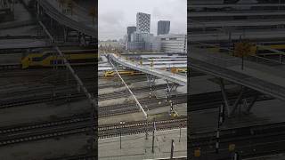 Wandel en fietsbrug met ijzerbomen over de sporen van het Centraal Station [upl. by Laiceps]