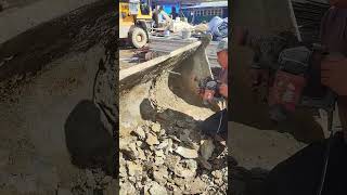 A worker uses a perforator to clean a loader bucket [upl. by Dirk]